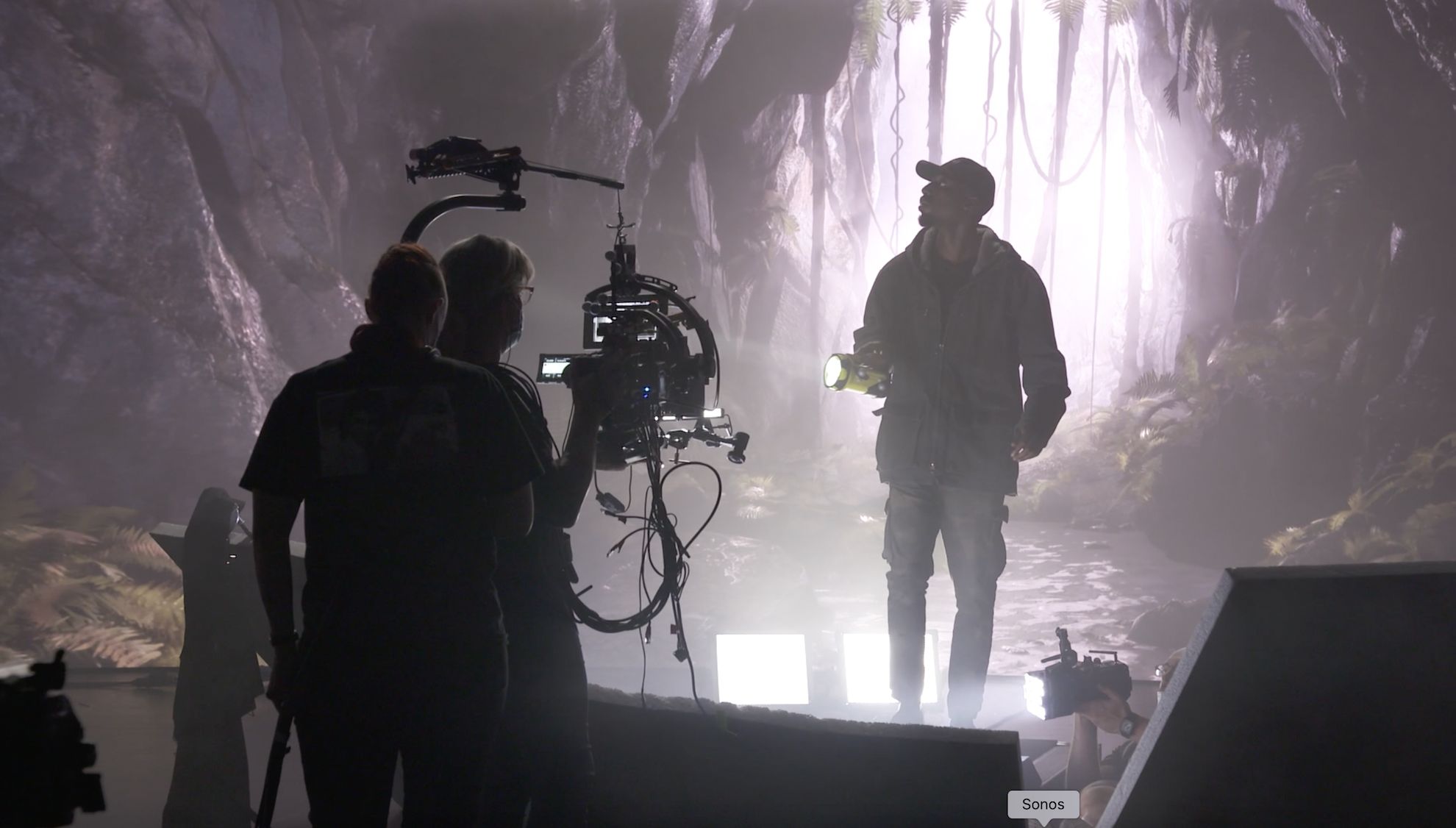 Man walking with a torch on a virtual production stage with camera operator in front