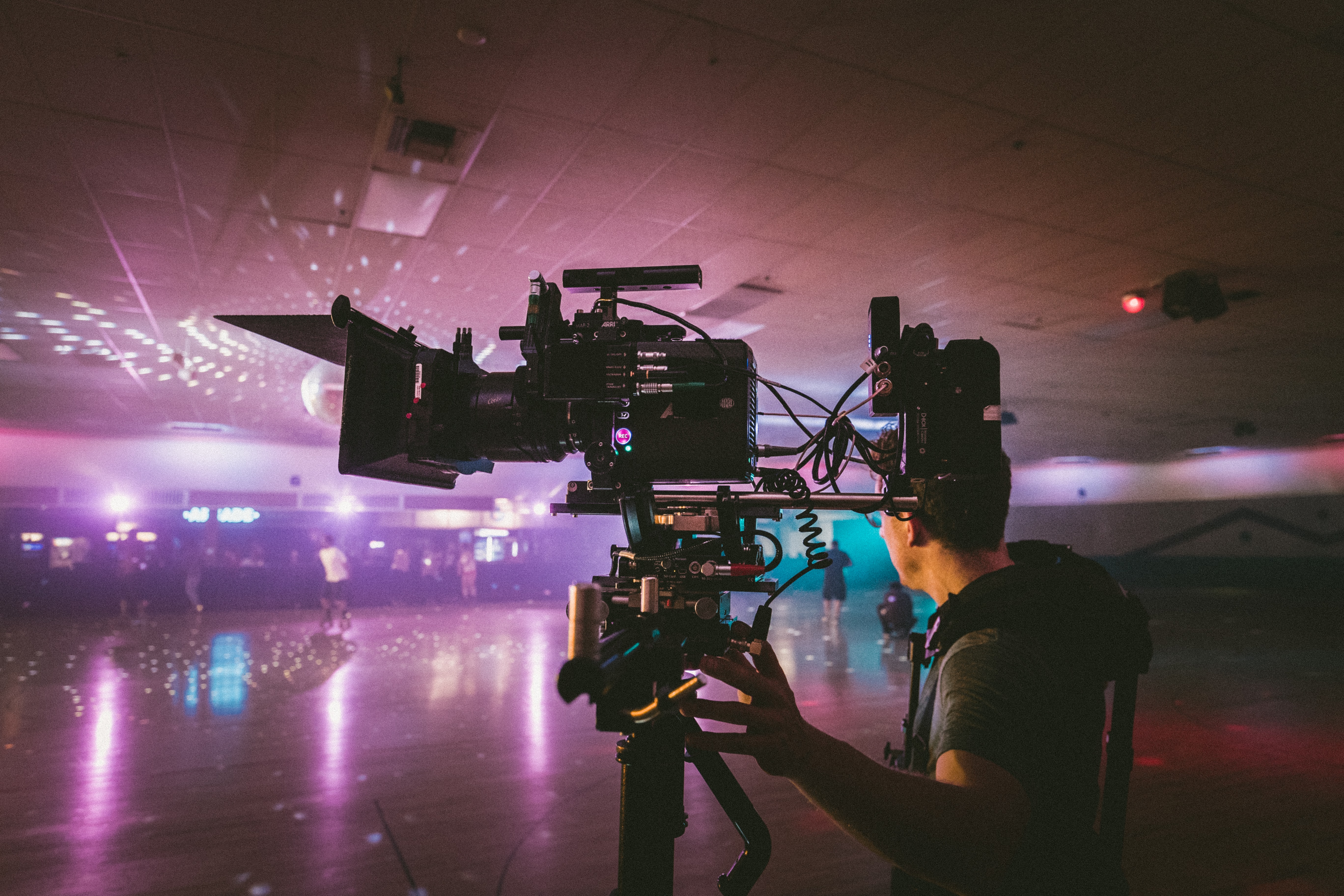 Cameraman holding a camera rig in a skating rink