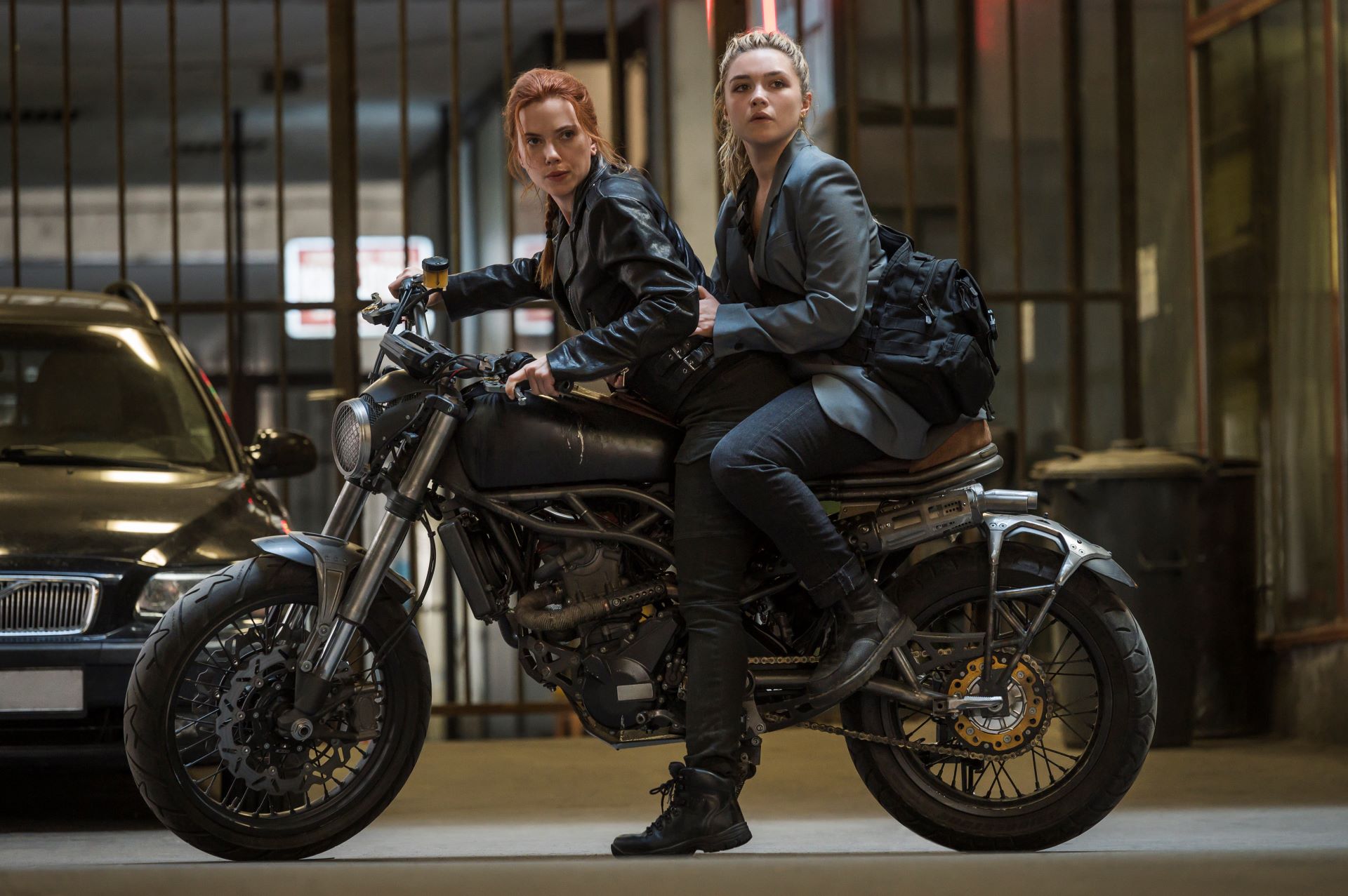 Scarlett Johansson and Florence Pugh on the back of a motorcycle dressed in black leather clothing