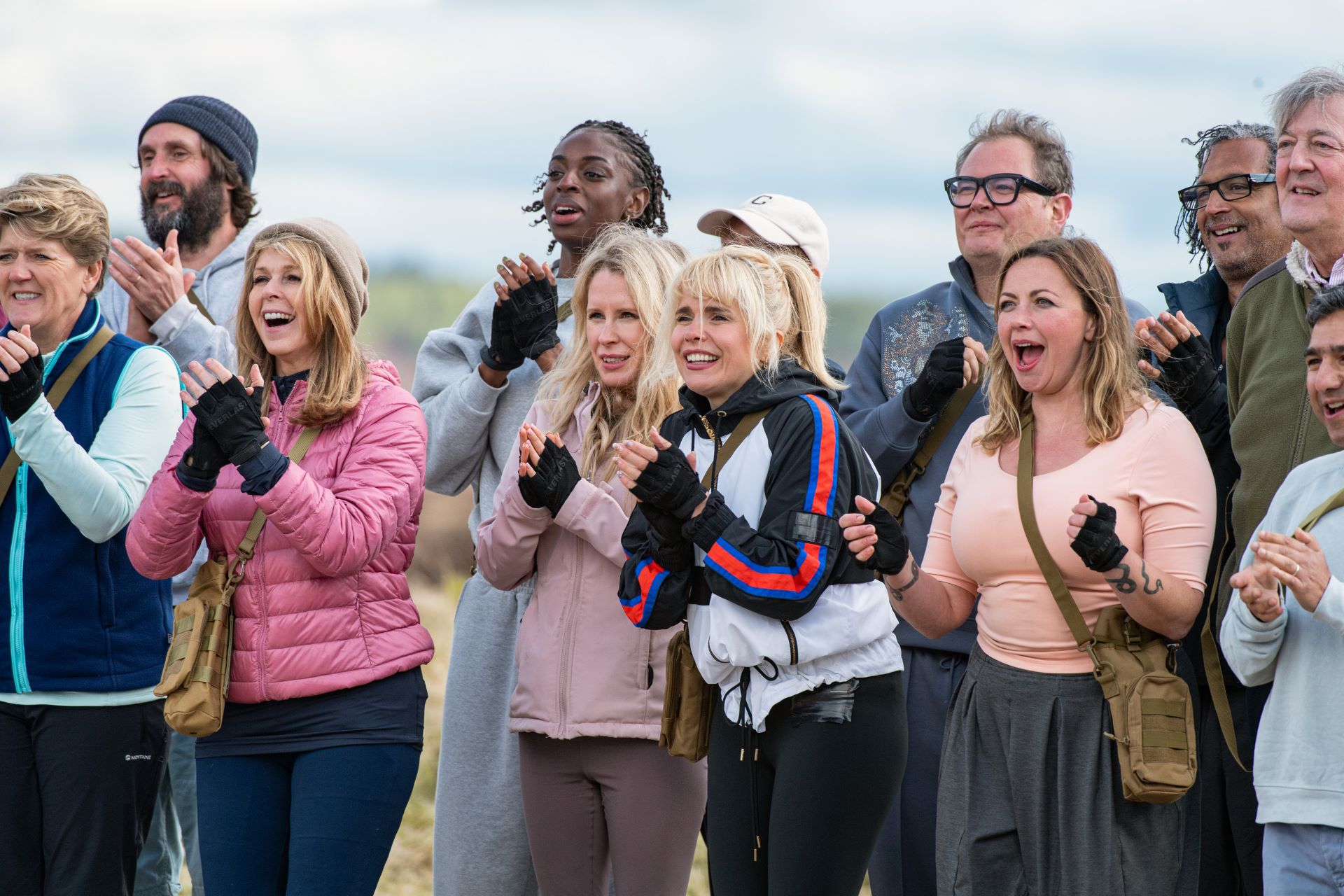 A group from the Celebrity Traitors stand cheering and clapping