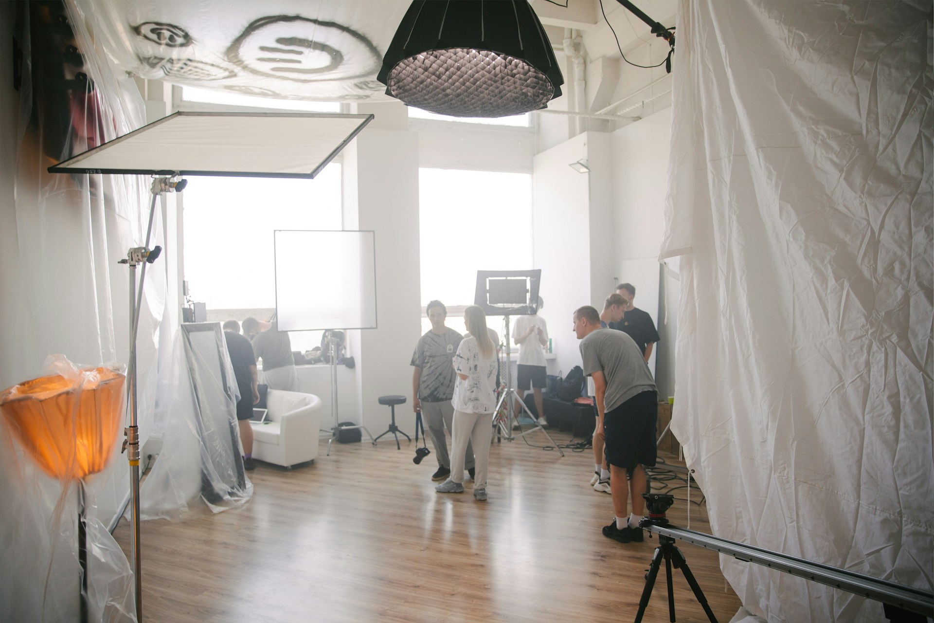 A team sets up an indoor shoot in a large room 
