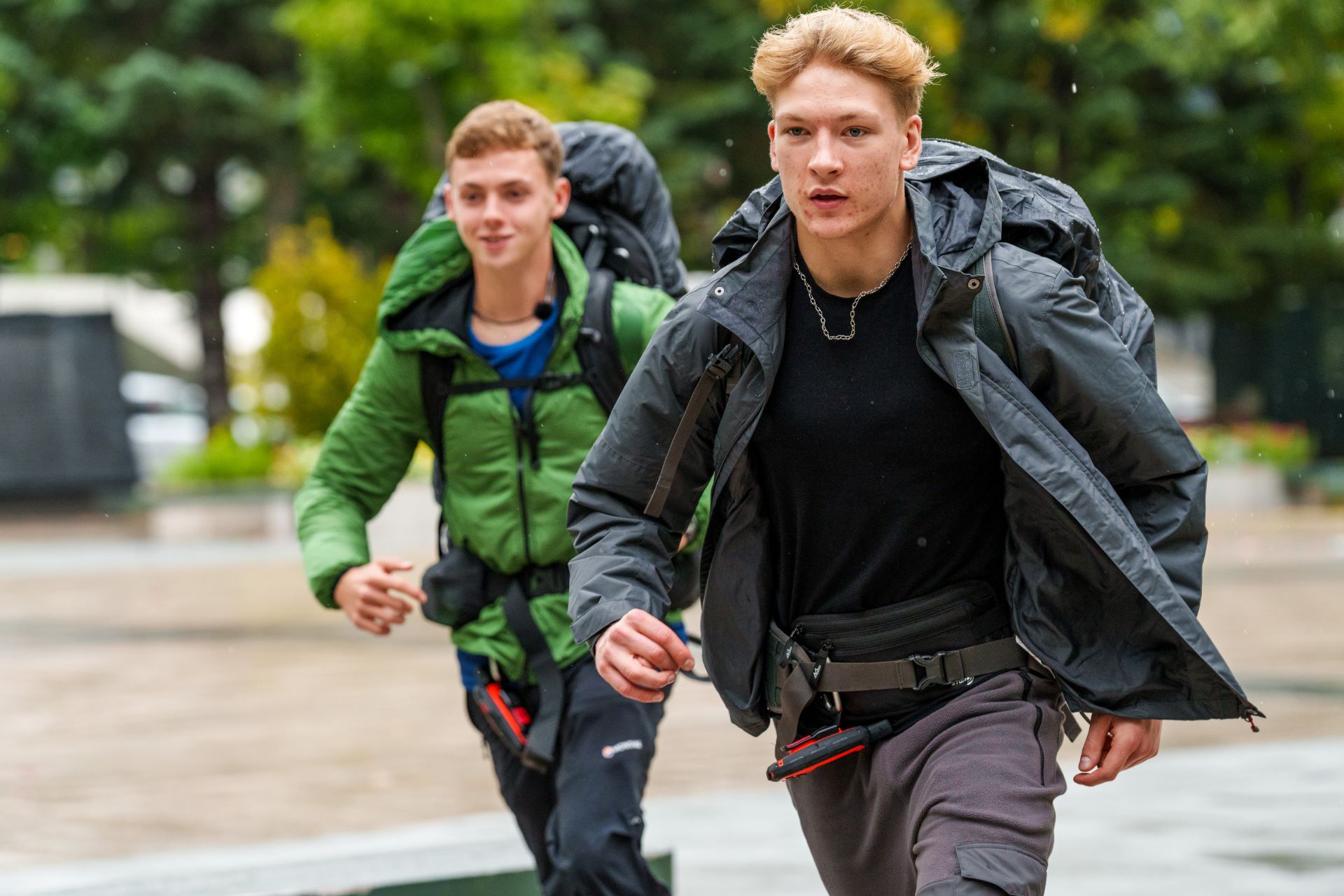 Two contestants on Race Across the World march along the street wearing backpacks