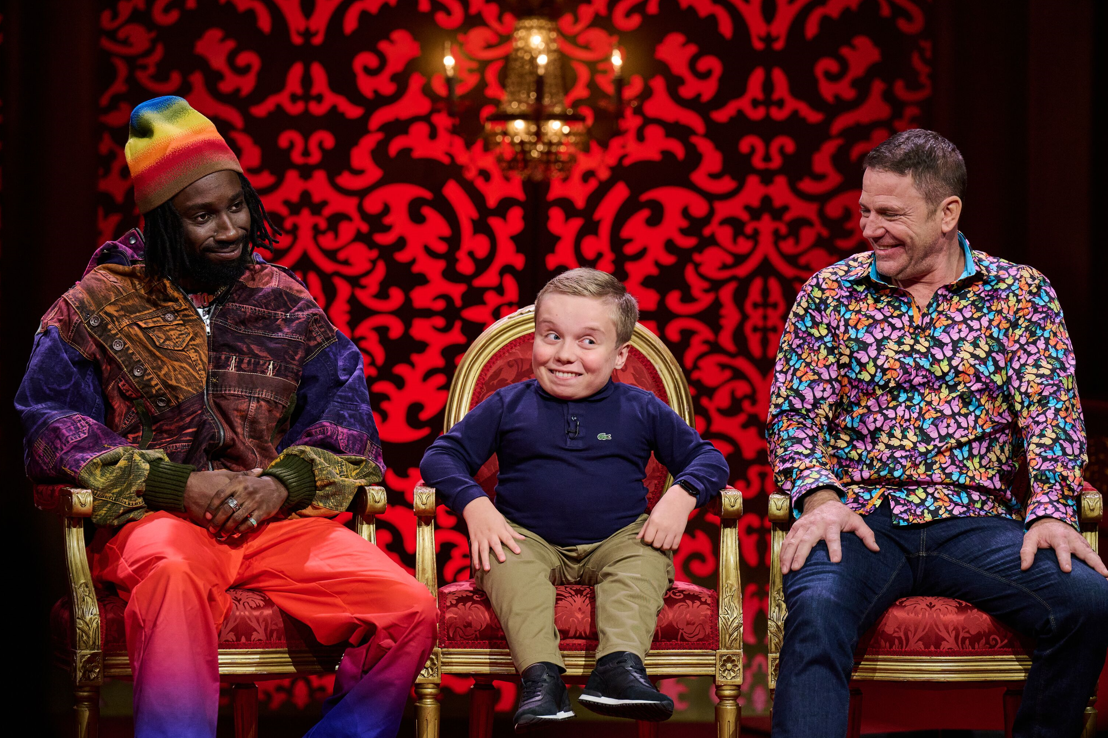 Taskmaster's Lenny Rush sits on a chair with two guests either side