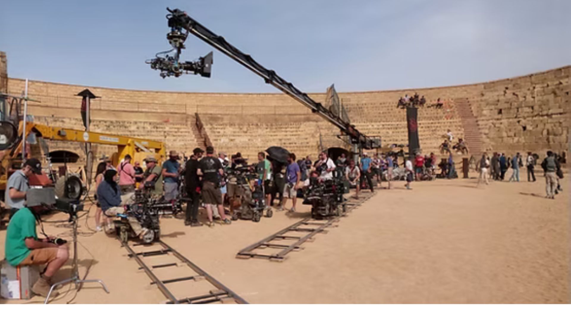 A busy film set with a large crane in the centre